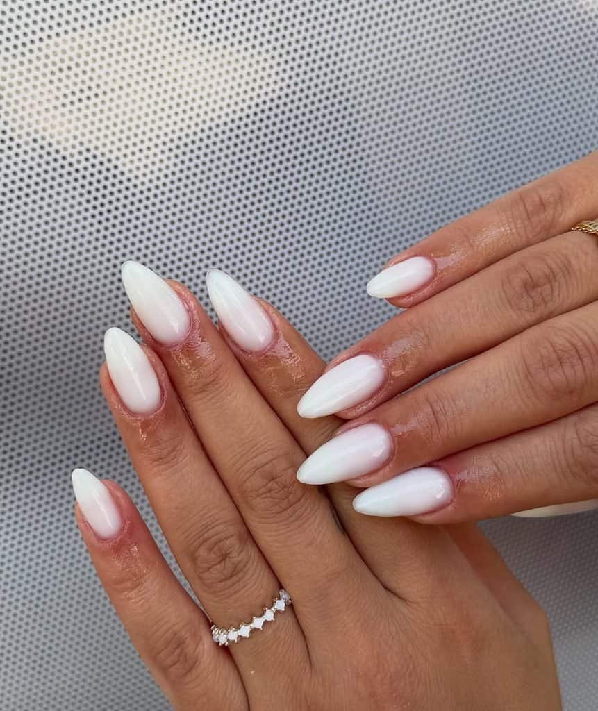 milky white ombre manicure with a soft gradient effect on pointed almond shaped nails