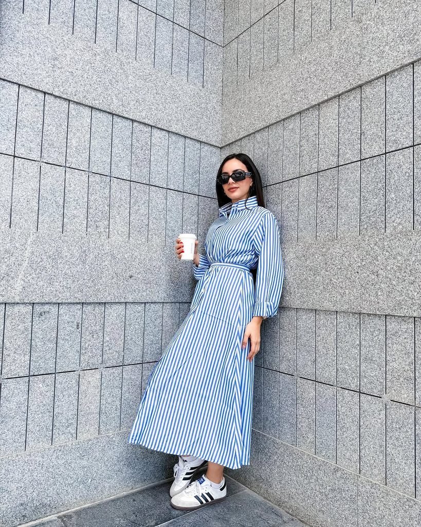 woman wearing blue and white striped maxi shirt dress paired with white sneakers