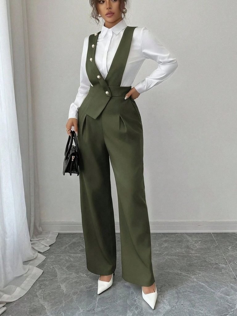 woman wearing white long-sleeve shirt under dark green sleeveless jumpsuit with wide-leg trousers