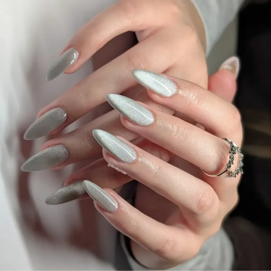 silver cat eye nails with a shimmering velvet finish on long almond shaped manicured hands