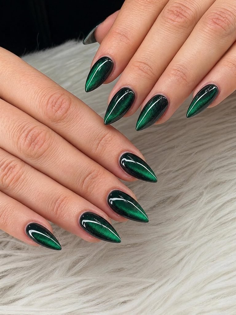long stiletto deep emerald green cat eye nails over a soft white faux fur background