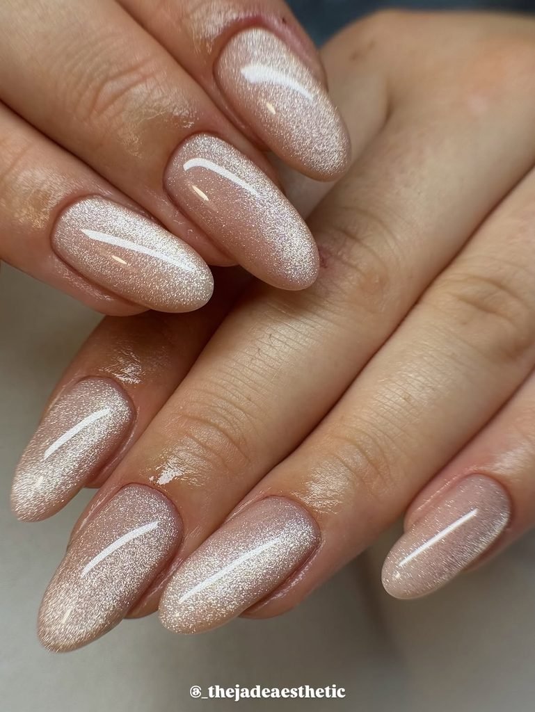 soft champagne nude cat eye nails with a shimmering silver magnetic streak
