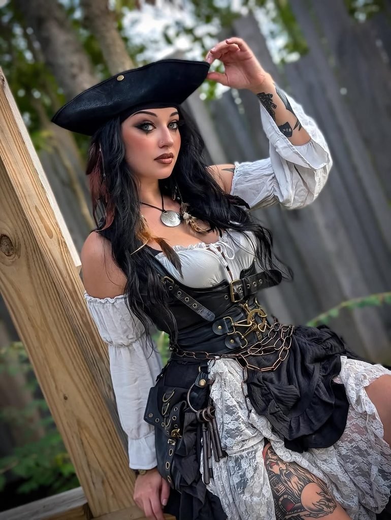 woman in a pirate costume wearing a tricorn hat black corset and white blouse