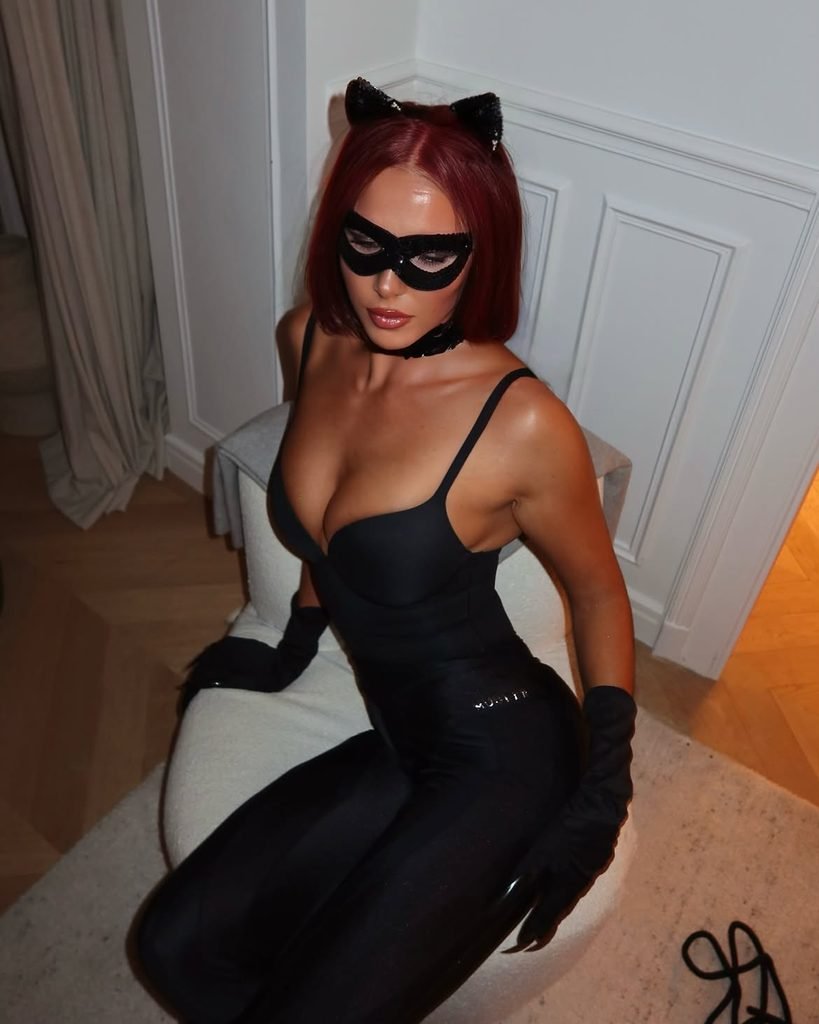 woman sitting in a chair wearing a black cat costume mask and ears