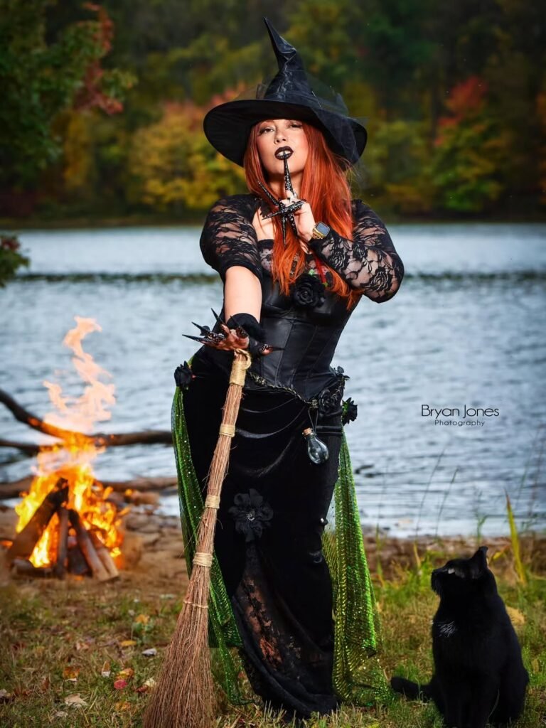 woman in a witch costume, wearing a black dress and pointed hat