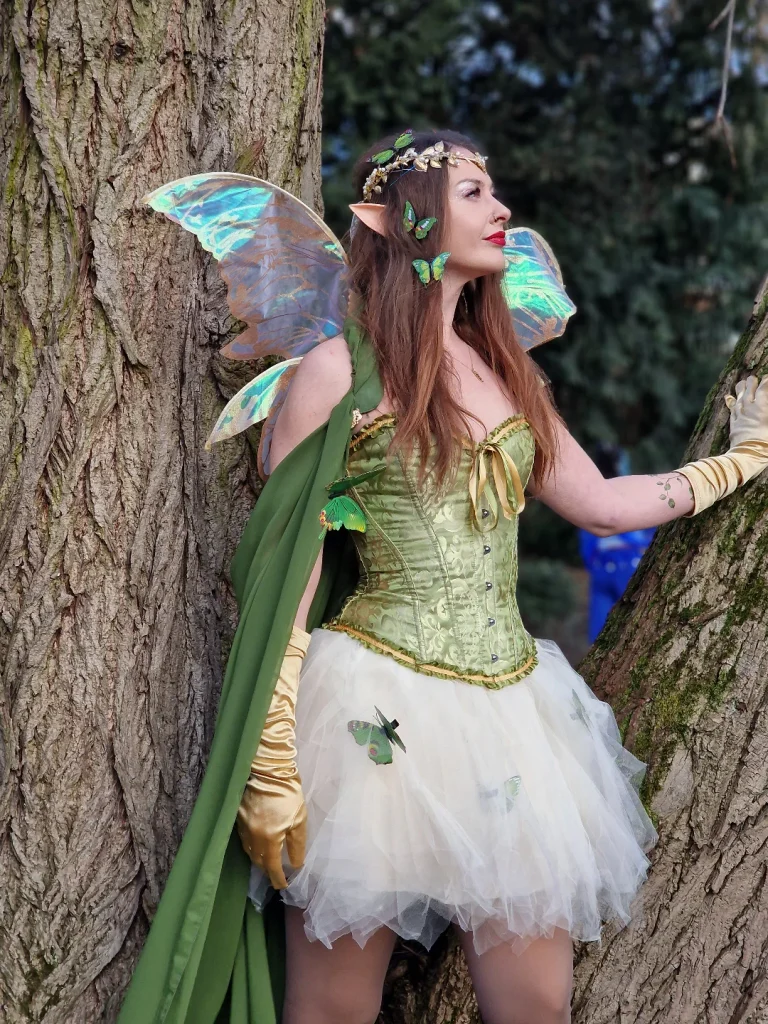 woman dressed as a green fairy with wings elf ears and a tulle skirt