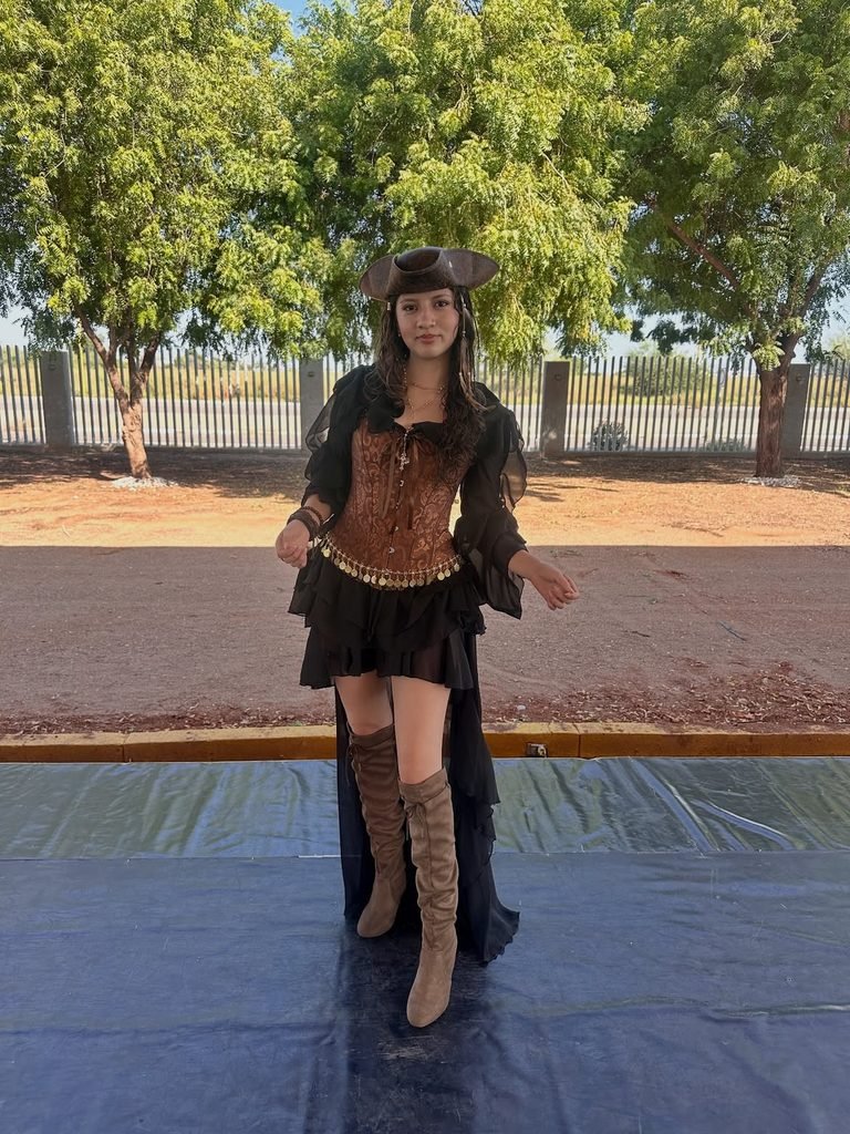 woman in a pirate costume wearing a brown corset dress hat and suede boots