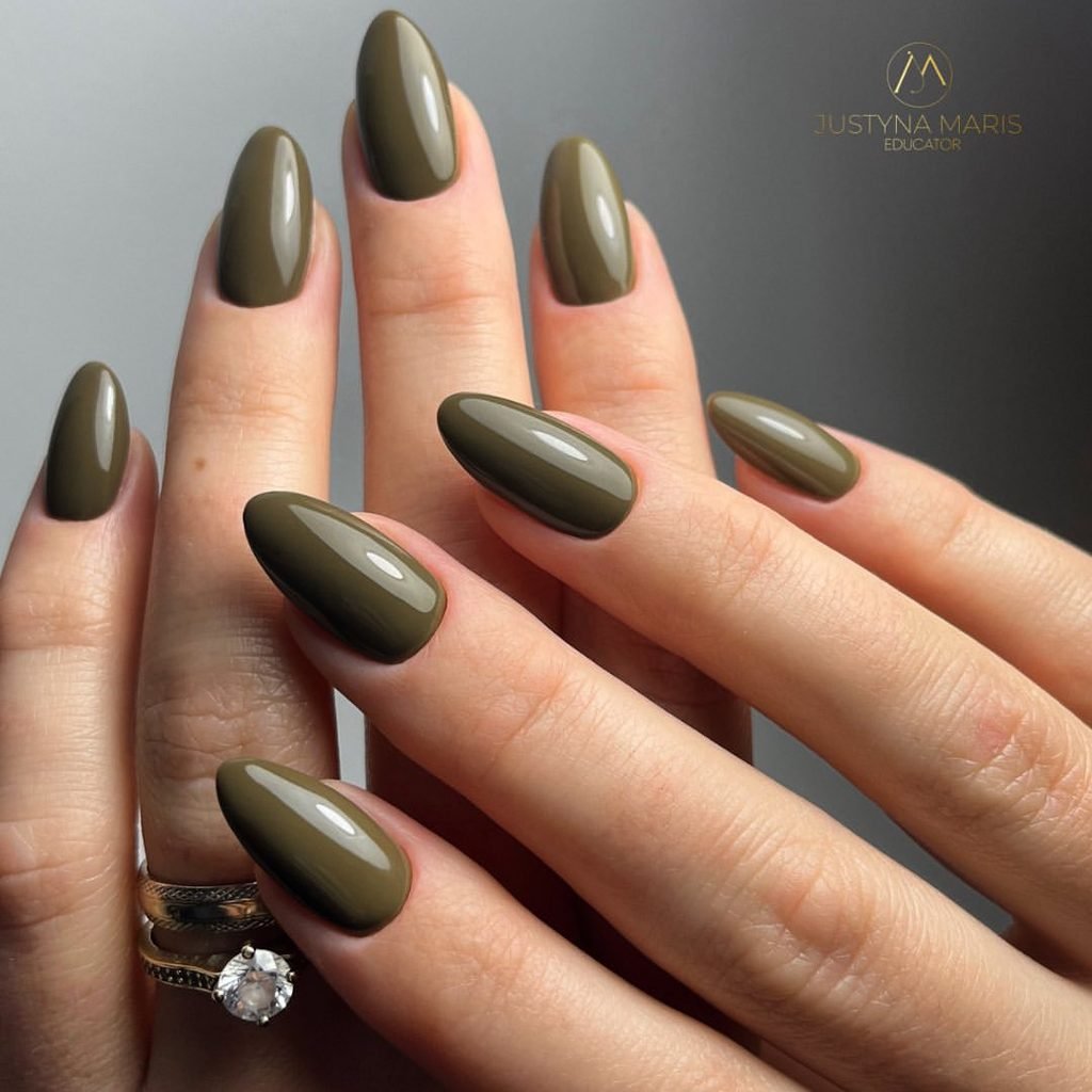 glossy olive green almond shaped nails on hands with a diamond ring