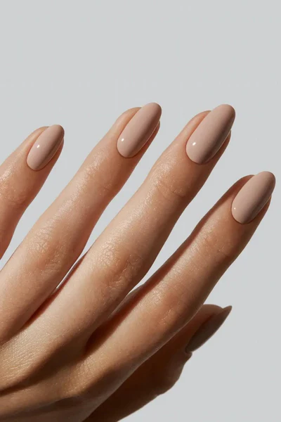 simple and clean glossy nude almond nails on a fair hand