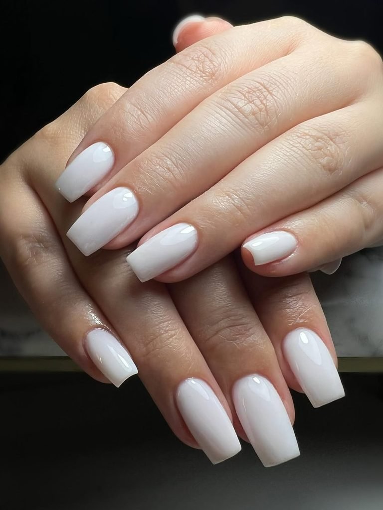 glossy milky white square manicure on elegant hands