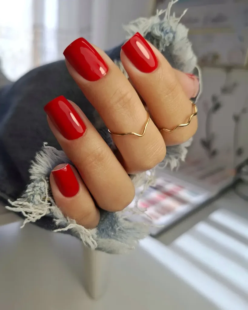 vibrant red square manicure with gold finger rings