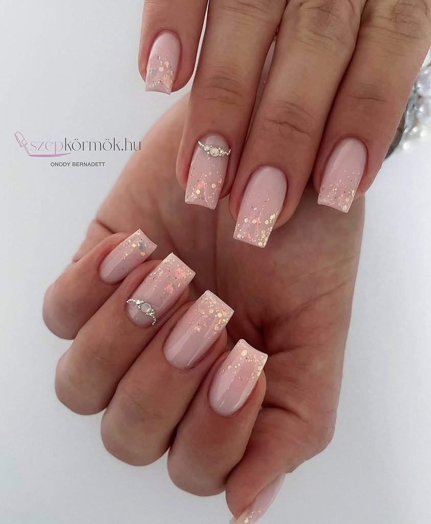 light pink square nails with glitter gradient and rhinestone accent