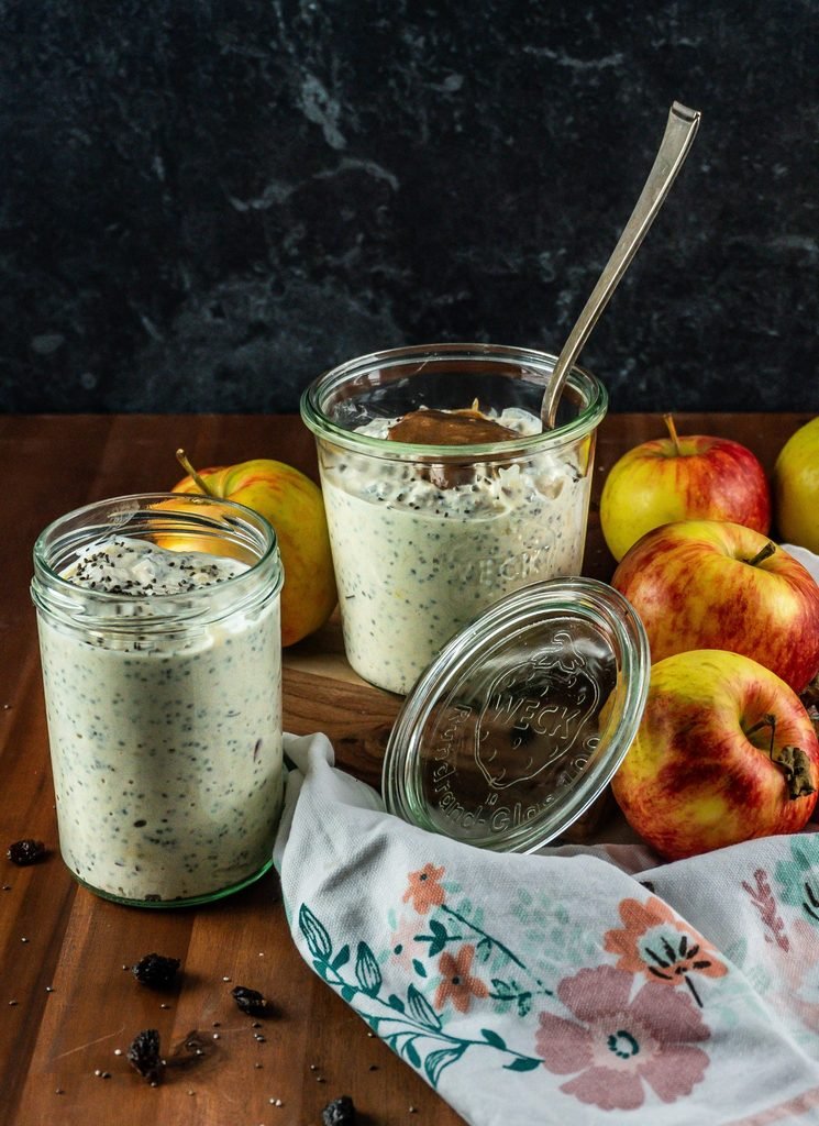 apple cinnamon chia seed pudding jars served next to fresh whole apples