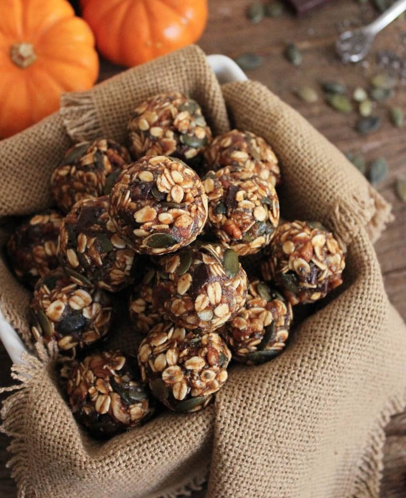 pumpkin pie energy bites made with oats and seeds stacked in a burlap container