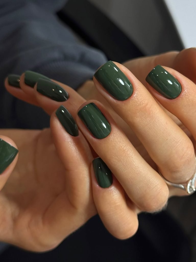 glossy dark olive green short square nails on hands resting together