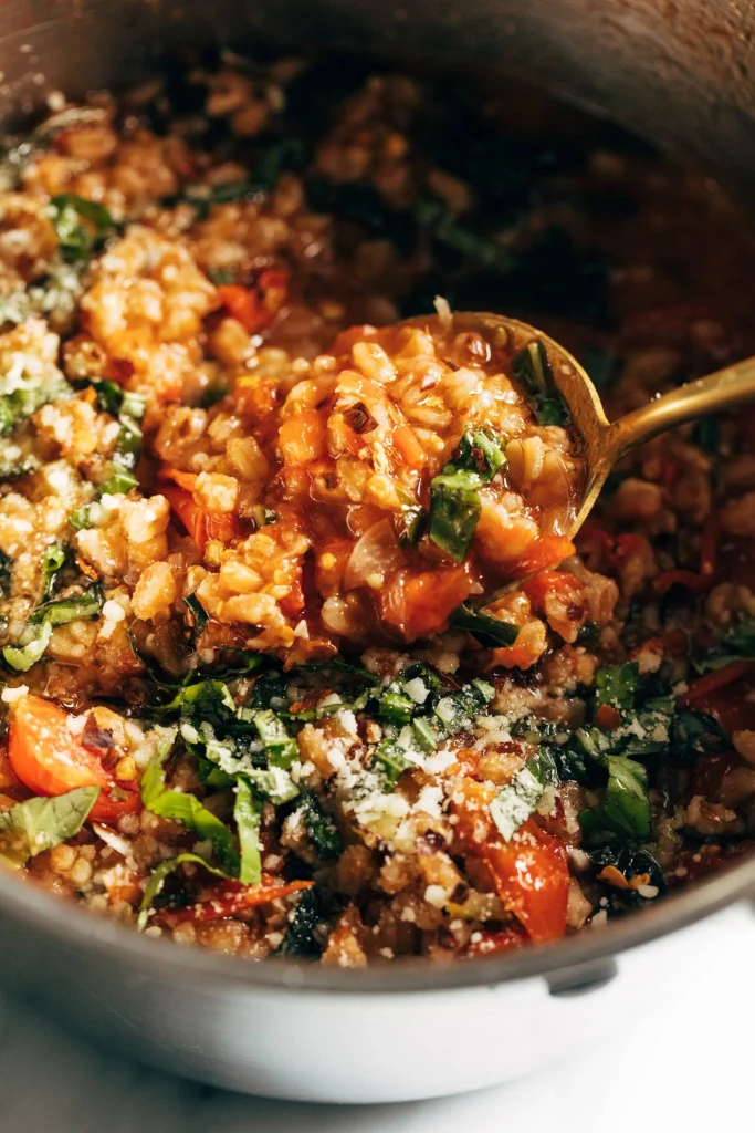 one pot farro cooked with tomatoes and herbs served hot with a metal spoon