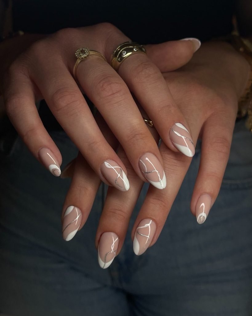 nude almond nails with abstract white swirl lines and fine silver accent detailing