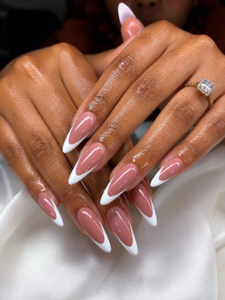 long almond french nails with crisp white curved tips on nude bases