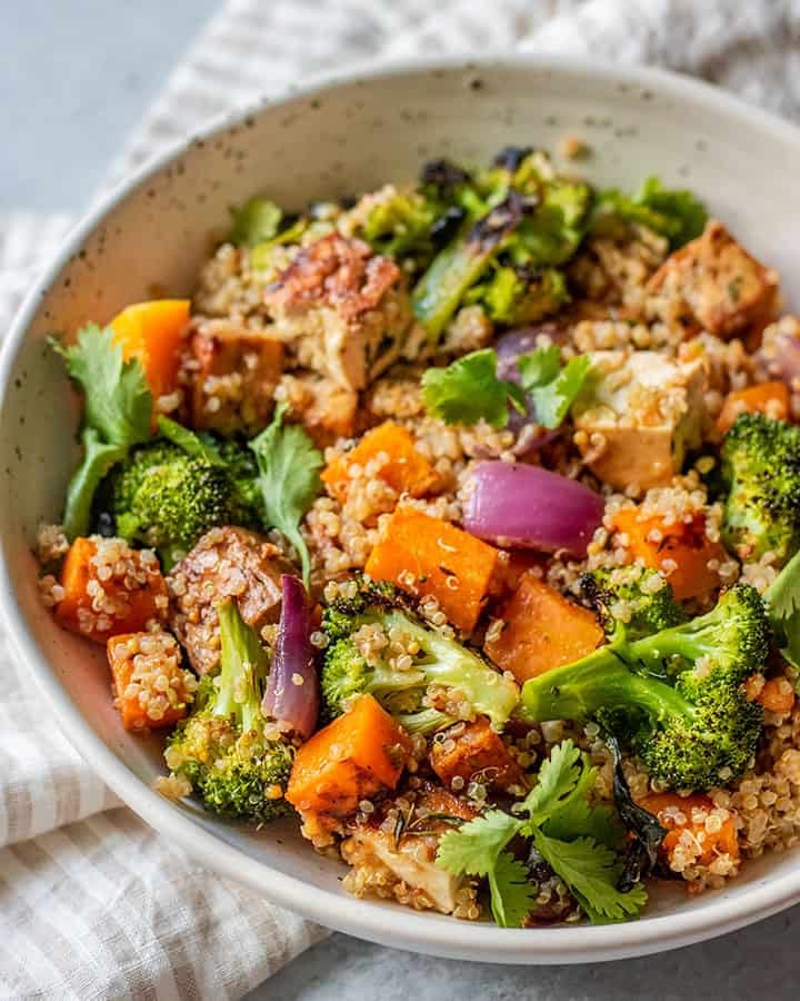 butternut squash quinoa bowl mixed with roasted broccoli, red onion, and cilantro