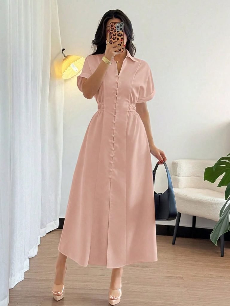 woman wearing a short sleeved button down light pink midi dress carrying a handbag