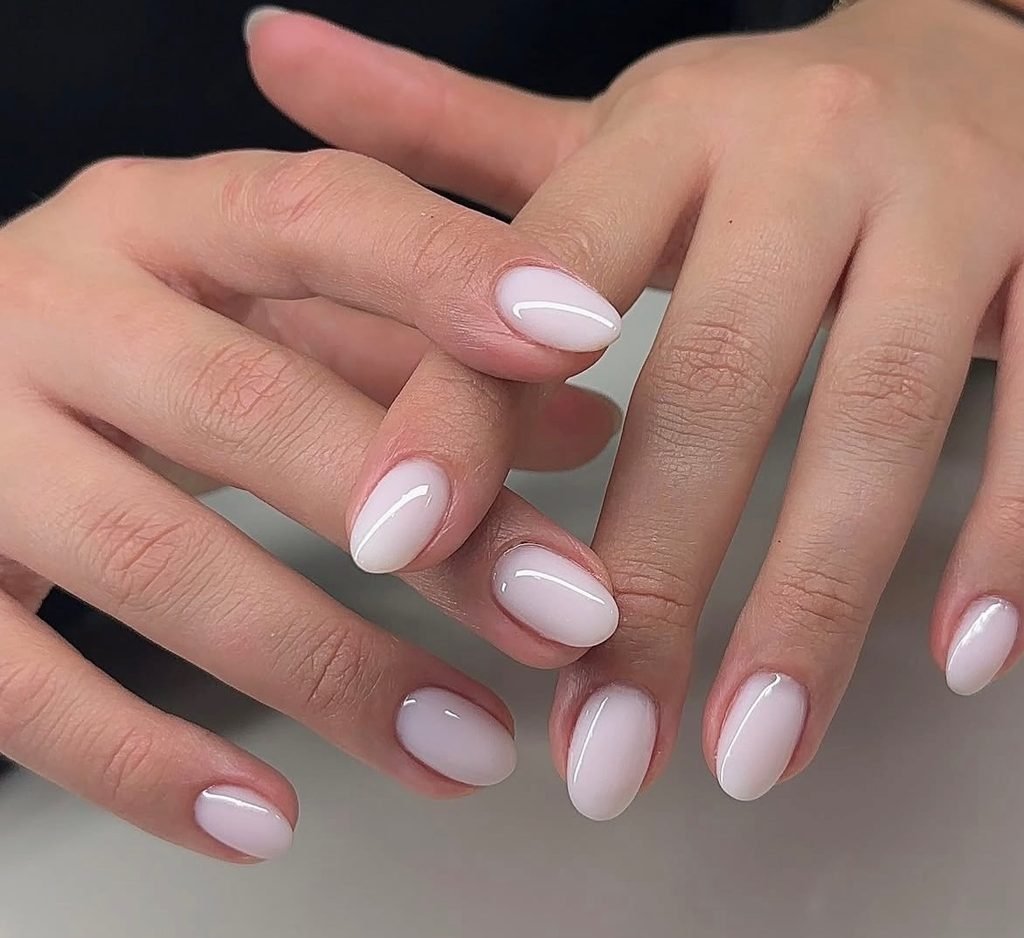 clean glossy milky white rounded nails on short natural fingers