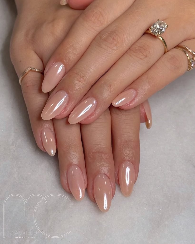 glossy sheer nude almond nails with subtle pearl shimmer polish finish
