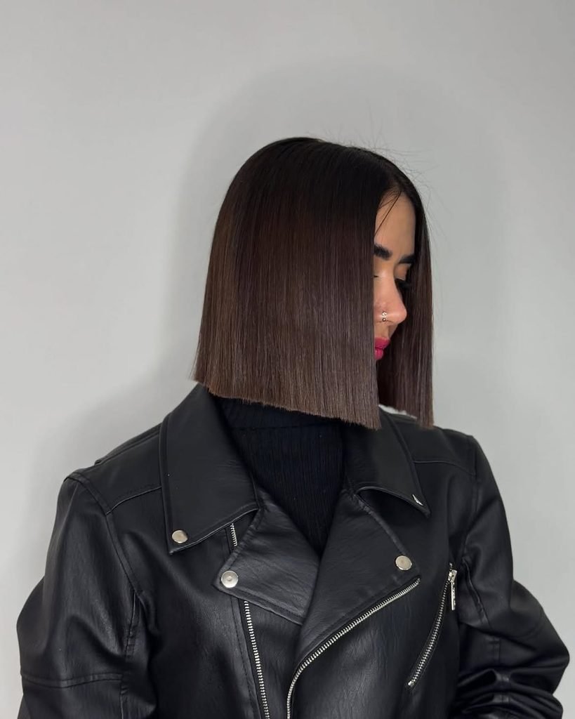 sleek blunt dark brown bob haircut with straight ends and black leather jacket