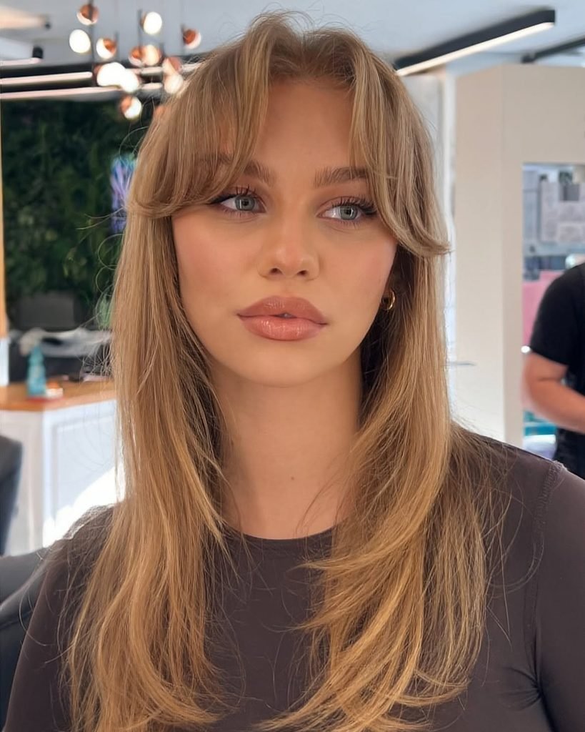 long blonde haircut with curtain bangs and soft face framing layers