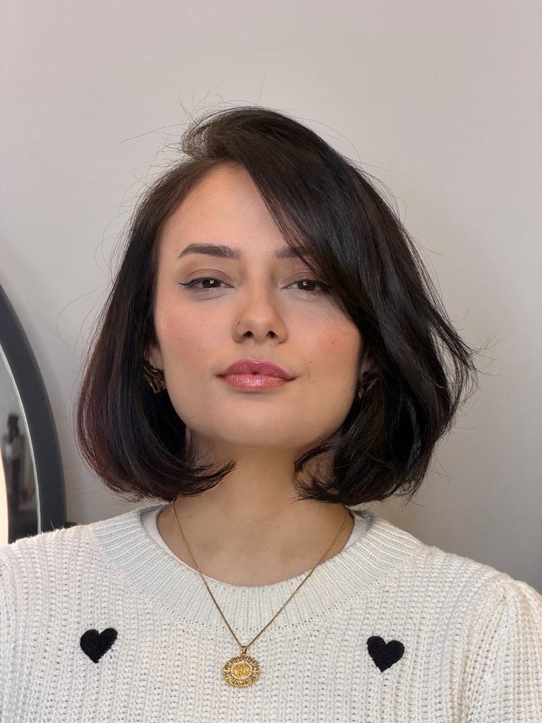 shoulder-length dark brown bob with side-swept bangs and softly curled ends