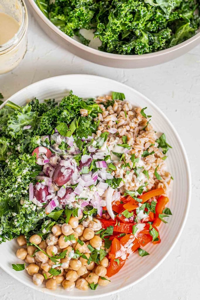 kale and farro salad bowl with chickpeas, red bell pepper, and olives