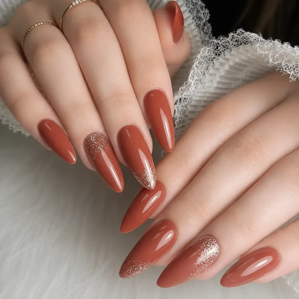 long terracotta almond nails with fine gold glitter ombre accents   