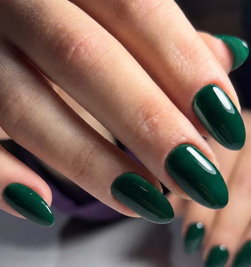 glossy emerald green almond nails showcased close up on a hand   