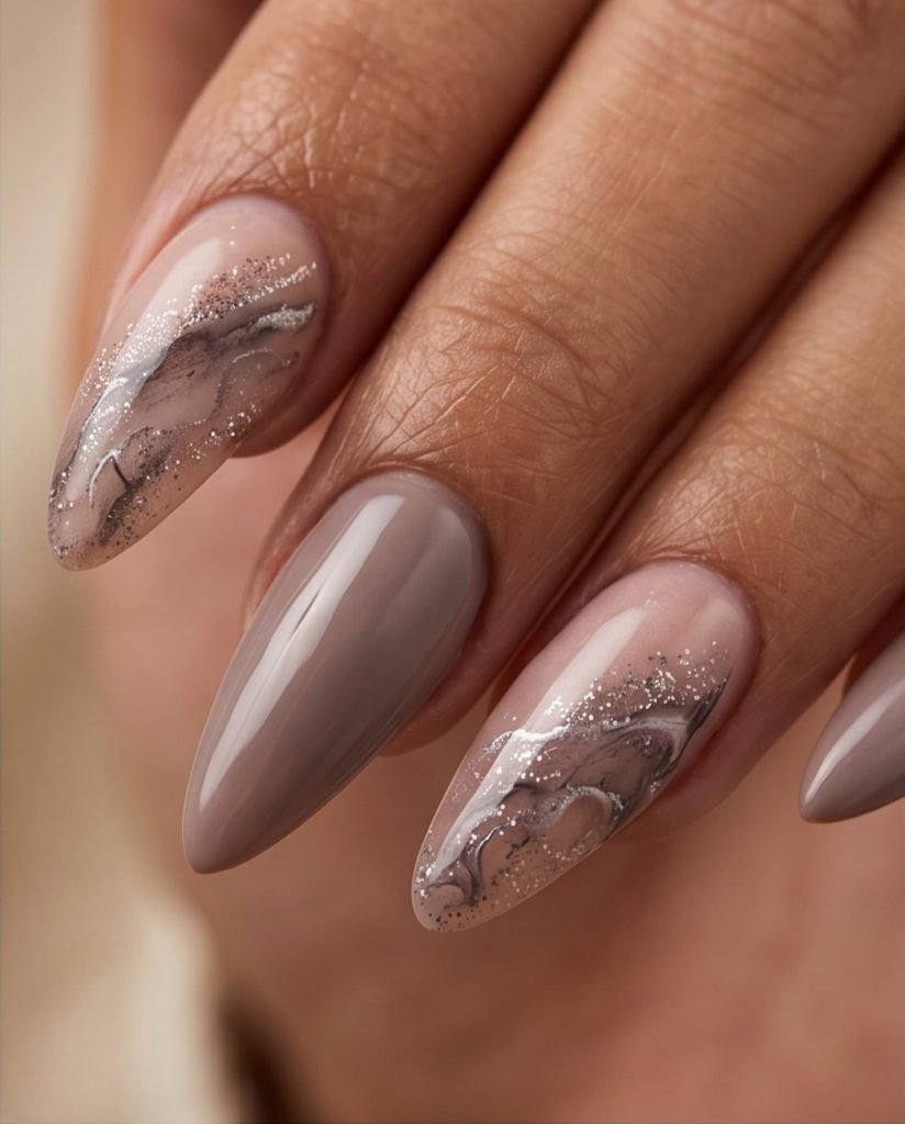 taupe almond nails styled with subtle smoky marble and glitter accents   
