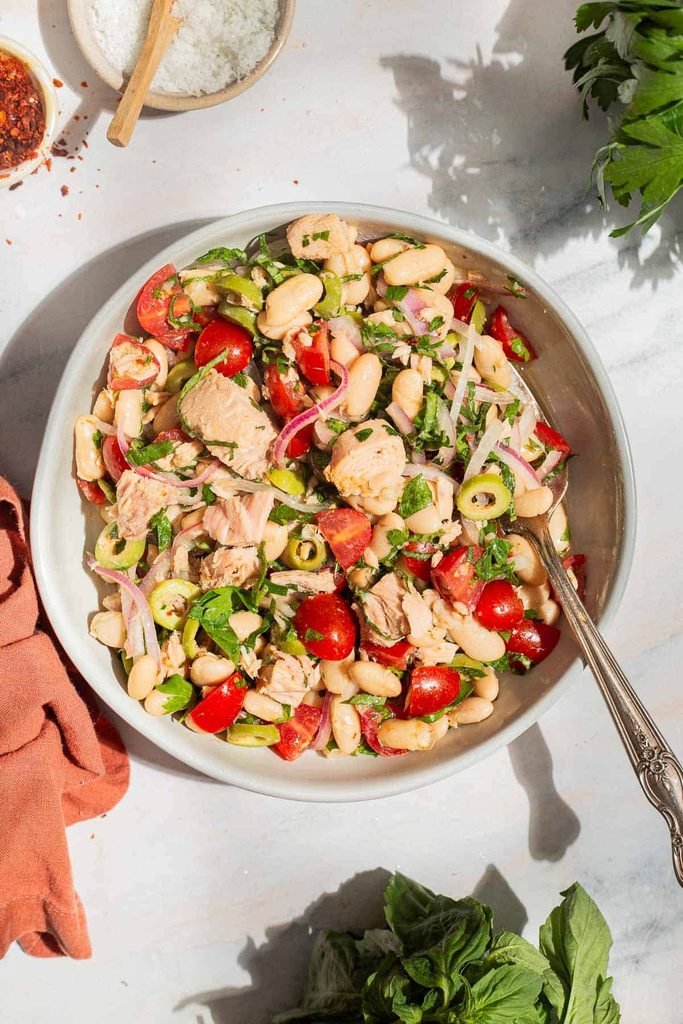 white bean and tuna salad tossed with cherry tomatoes, parsley, and sliced red onion