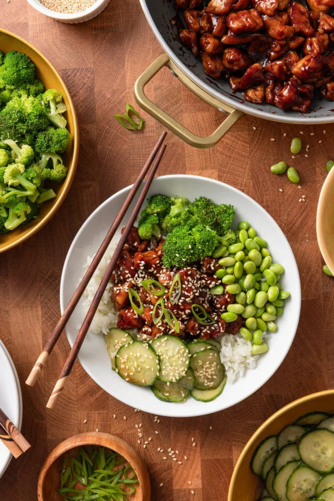 chicken teriyaki bowl with steamed rice, broccoli, edamame, and cucumber slices