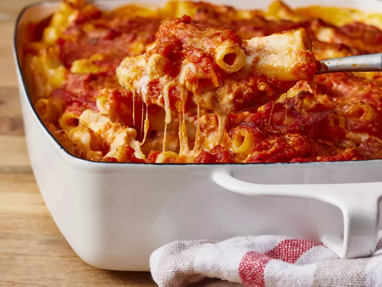 baked ziti casserole with melted cheesy string pulling up on a spoon   