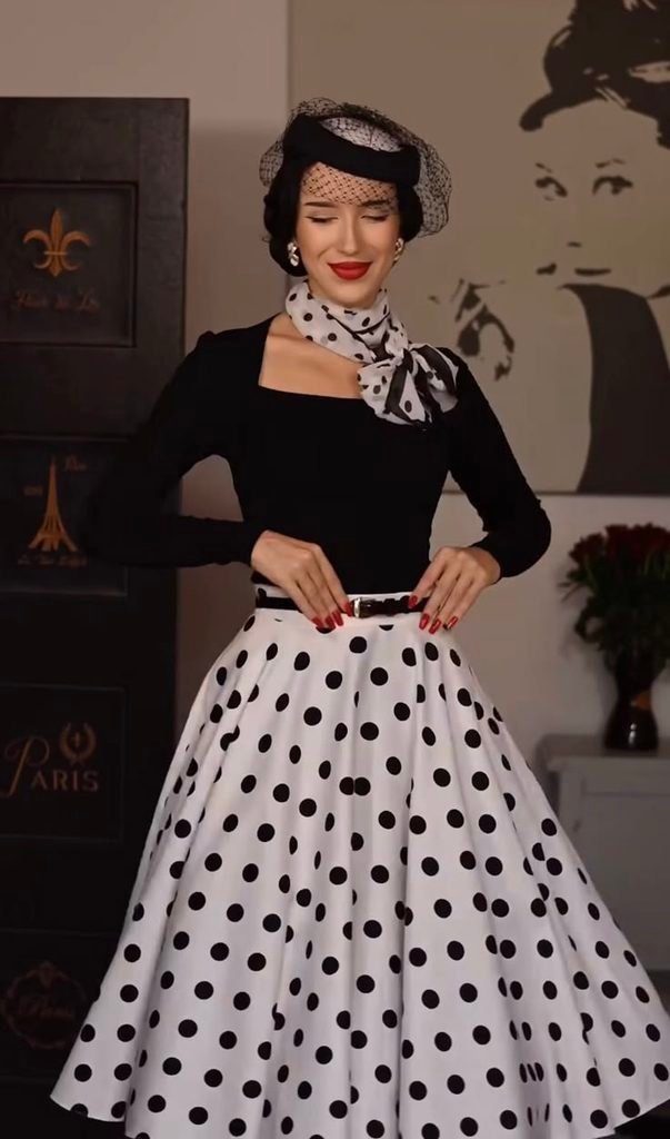 woman wearing a vintage black long sleeve top and a white black polka dot swing skirt