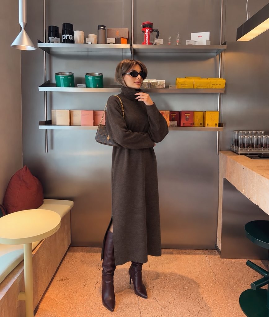woman wearing a dark brown turtleneck sweater dress paired with high leather boots