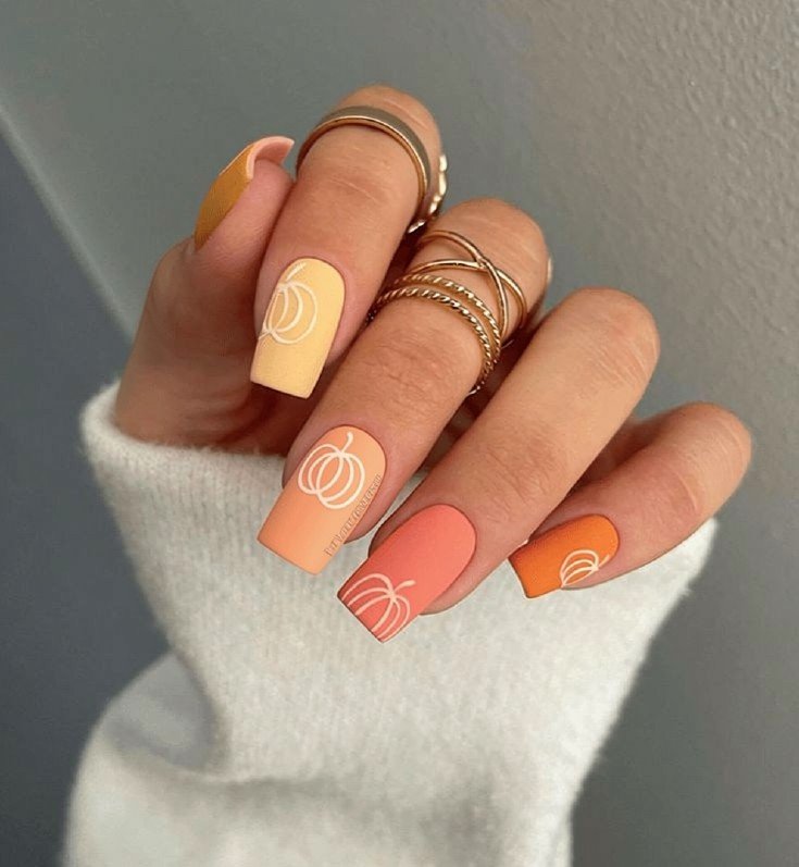 matte square autumn nails in gradient shades with white outline pumpkins