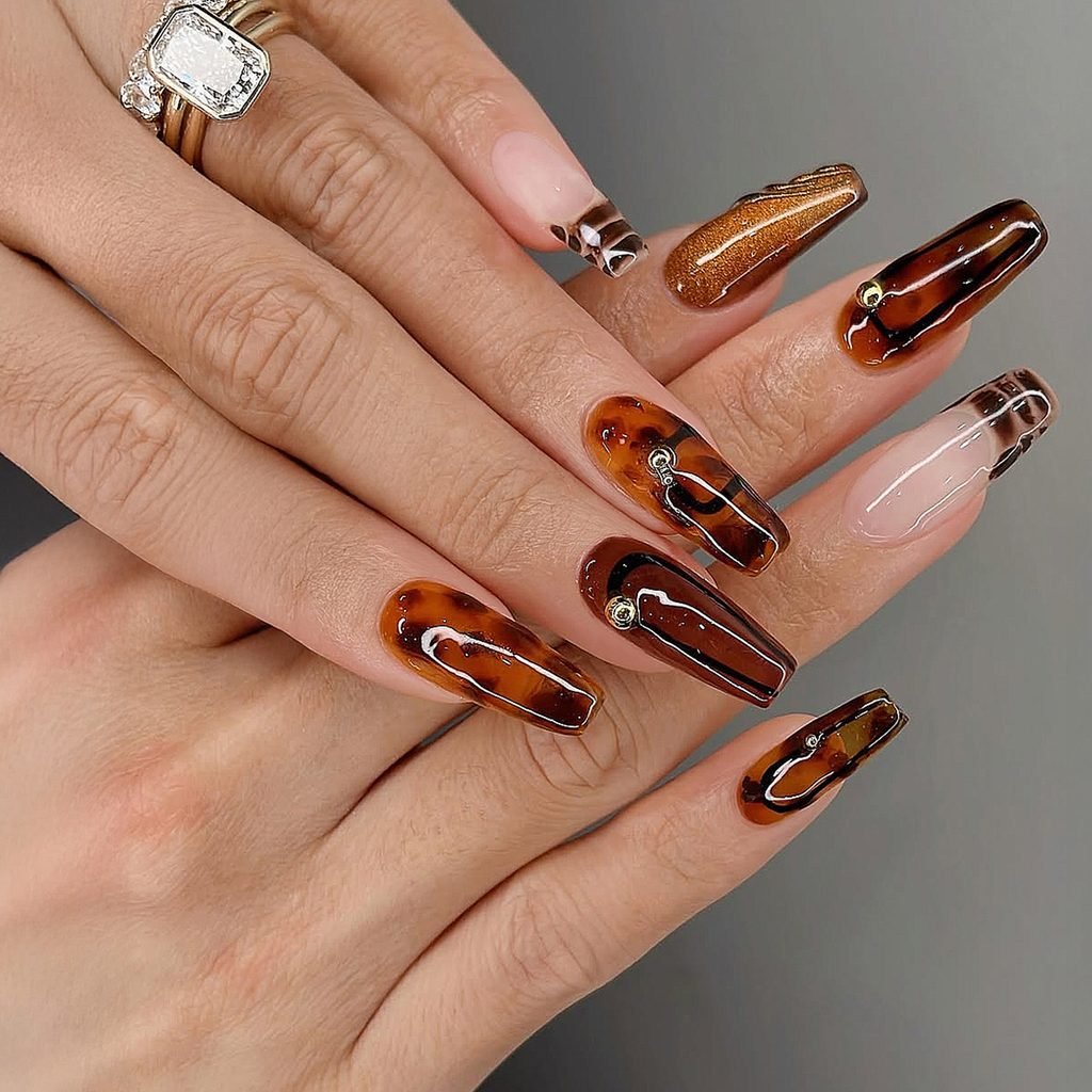 long coffin nails with glossy brown tortoiseshell art, french tips, and gold accents