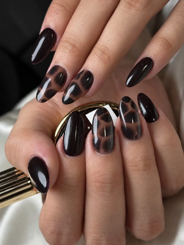 glossy dark brown and black tortoise shell print manicure on almond nails