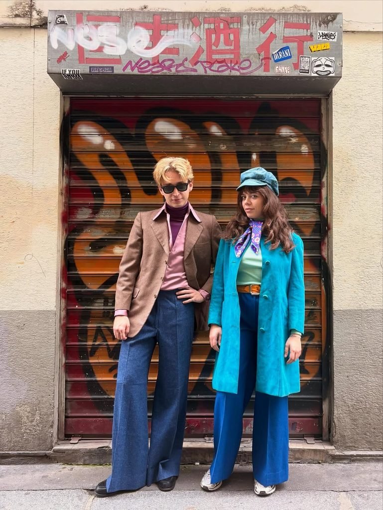 man and woman posing outdoors in retro seventies outfits with wide bell bottoms