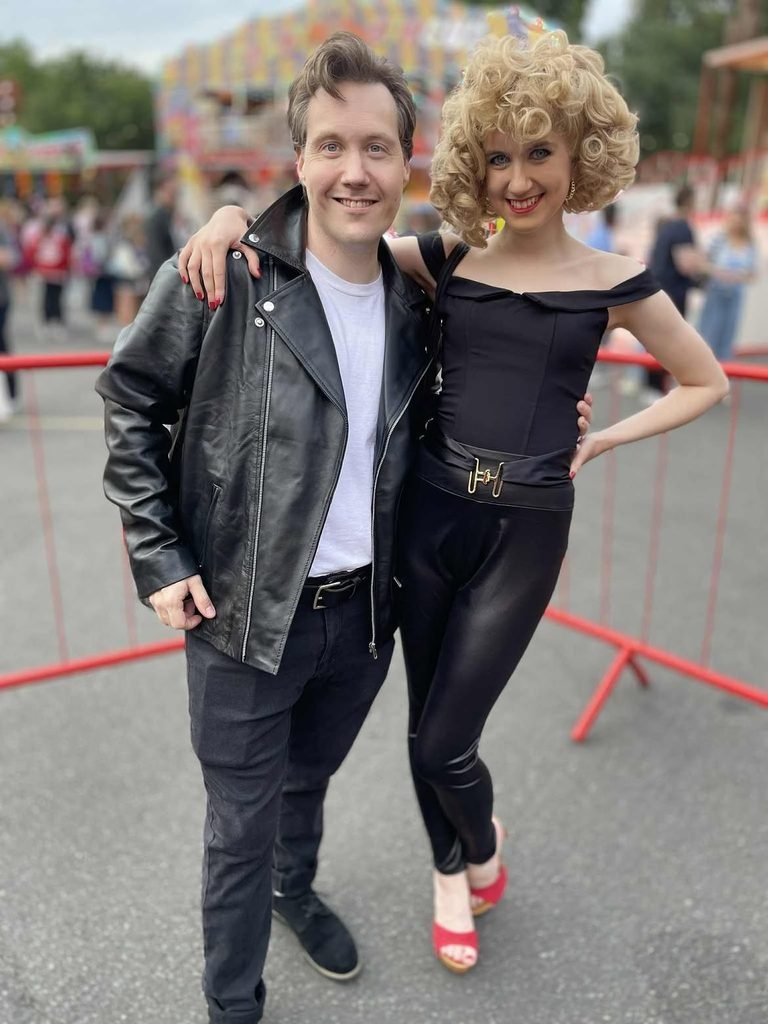 man in a leather jacket and woman with blonde curls dressed as grease characters