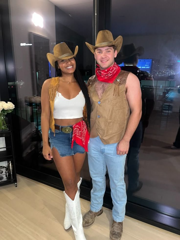man and woman posing together wearing western cowboy costumes with brown hats