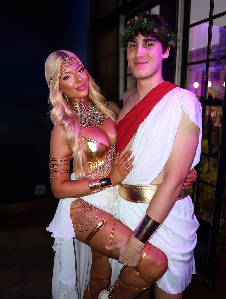 man and woman posing together dressed in ancient roman goddess and toga costumes