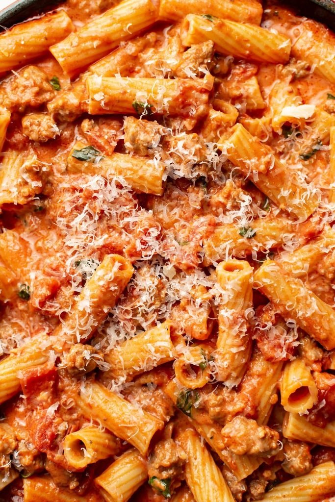rigatoni pasta coated in creamy sausage sauce and sprinkled with parmesan cheese   
